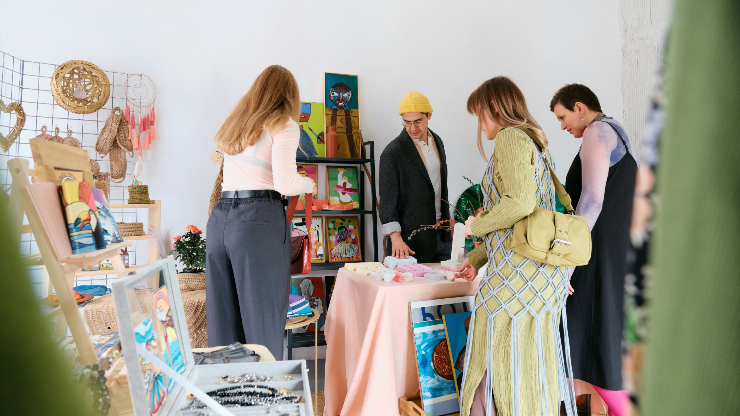 Four people shopping at an indoor craft fair.